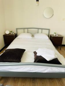 a large bed with white sheets and brown pillows at Apartament Szczerbowskiego B in Lublin