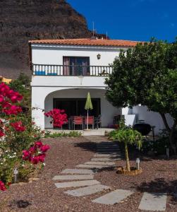 a white house with a patio and a tree at Wohnung in Playa De La Calera mit Privatem Parkplatz in Valle Gran Rey