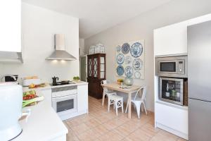 a kitchen with white appliances and a table with chairs at El Balcon de Salinetas MF by VillaGranCanaria in Telde