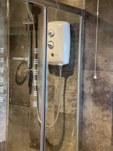 a shower with a soap dispenser in a bathroom at Durham City Cottages in Durham