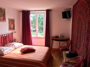 a bedroom with a bed and a window at La Longre in Cerisy-la-Forêt