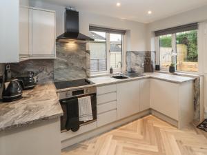 a kitchen with white cabinets and a sink at 12 Merefell Road in Carnforth