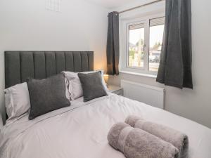 a bedroom with a large white bed with a window at 12 Merefell Road in Carnforth
