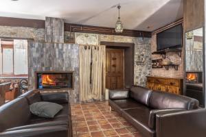 a living room with a leather couch and a fireplace at Caserío Zubieta in Orózqueta