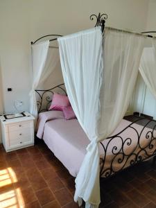 een slaapkamer met een hemelbed bij Il Castello degli ulivi in Roccella Ionica