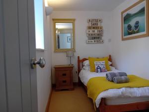 a small bedroom with a bed and a mirror at The Barn in Penzance