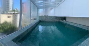 a swimming pool in a building with blue water at Hotel Sibara SPA & Convenções in Balneário Camboriú +62 photos