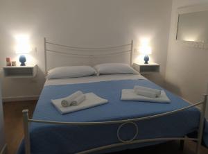 a bedroom with a bed with two towels and two lamps at Dimora d'Estate (Sicilian Holidays) in Milazzo