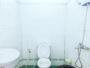 a white bathroom with a toilet and a sink at VangVieng Ruby'Homestay in Vang Vieng
