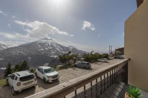 un groupe de voitures garées sur un parking avec une montagne dans l'établissement Studio Alaskan - Studio lumineux vue montagne, à Orcières