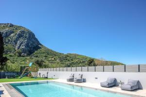 uma piscina com uma montanha ao fundo em Del Sur Luxury Villa, Absolute Privacy & Comfort, By ThinkVilla em Lefkogeia