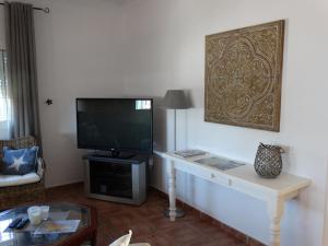een woonkamer met een flatscreen-tv en een tafel bij Villa Las Campanas in Periana