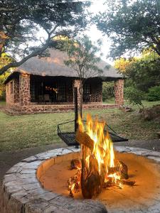 a fire pit in front of a stone building at Moletani Game Ranch in Kareefontein