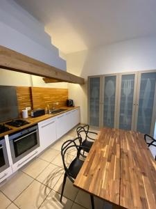 eine Küche mit einem Holztisch und Stühlen in der Unterkunft VICTOR HUGO in Amiens