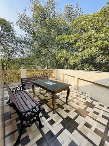 une table et un banc sur une terrasse dans l'établissement Hotel Golden - Premiums Rooms in South Extension, à New Delhi