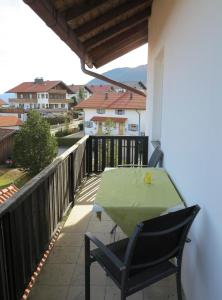 patio con mesa verde y sillas en el balcón en Hike 'n Bike Base, en Bad Kohlgrub