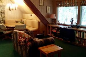 un soggiorno con divano e tavolo di Historic Big Mountain Chalet Upper a Whitefish