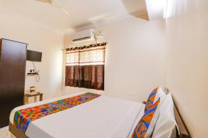 a bedroom with a bed and a window at FabHotel Opal Residency in Hyderabad