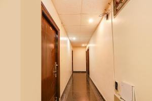 a hallway with a door and a long corridor at FabHotel Opal Residency in Hyderabad