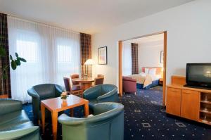 ハンブルクにあるHI Hotel International Hamburgのテレビとリビングルームが備わるホテルルームです。