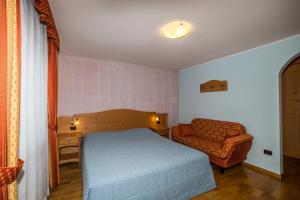 a bedroom with a bed and a chair at Affittacamere Villa Belfiore in Ronzone