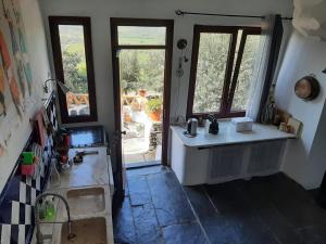 uma cozinha com um lavatório e vista para um quintal em Casas Letizia e Sebastião em Monsaraz mais 37 fotografias