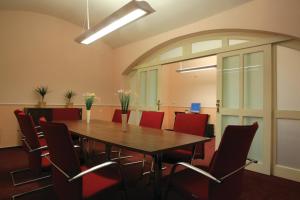 sala konferencyjna z drewnianym stołem i czerwonymi krzesłami w obiekcie Anna Hotel w Pradze