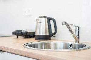 a kitchen sink with a tea kettle on a counter at GuestReady - São Domingos - The Cathedral in Porto