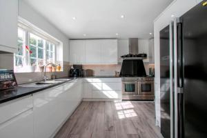 a kitchen with white cabinets and stainless steel appliances at BOURNECOAST: *HOT TUB*BBQ HUT*GYM*GARDEN* HB6340 in Bournemouth