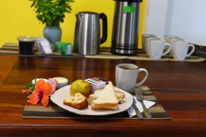um prato de pão e fruta e uma chávena de café em Lampião Hostel em Florianópolis