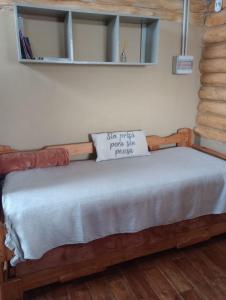 1 dormitorio con cama de madera y almohada en CABAÑAS PIRCAS DE CAMPO in 