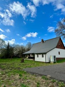 Biała stodoła z szarym dachem na polu w obiekcie V Údolí w mieście Jablonné v Podještědí