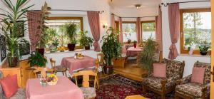 a restaurant with tables and chairs and plants at KREUZHOF Seefeld in Seefeld in Tirol