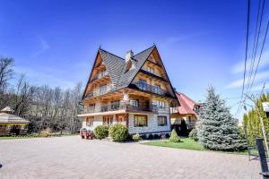 a large wooden house with a gambrel roof at Domek u Horarów in Ciche