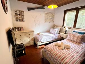 1 dormitorio con 2 camas y TV. en La Closette, en Rovagny