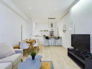a living room with a couch and a tv and a table at Pass the Keys Stylish 4-Bed3-Bath in Shoreditch in London