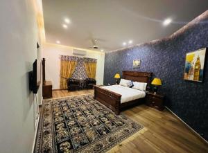 - une chambre avec un lit, un canapé et une télévision dans l'établissement Pearl Executive Villa Islamabad, à Islamabad
