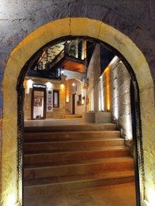 アヴァノスにあるSakli Cave Houseの建物の階段につながるアーチ道