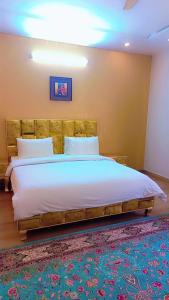 a bedroom with a large bed with a wooden headboard at Pearl Executive Villa Islamabad in Islamabad