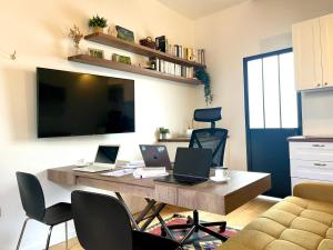 a desk with two laptops on it in a living room at Vieux Marly-le-Roi - Studio bien equipé - Matelas haut qualité in Marly-le-Roi