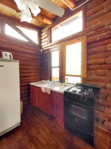 a kitchen with a stove and a sink in a cabin at CABAÑAS PIRCAS DE CAMPO in Tanti