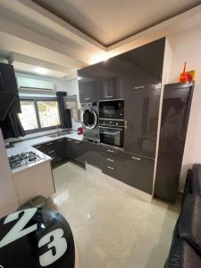 a kitchen with black cabinets and a stove top oven at Appartement Haut Standing in Dakar