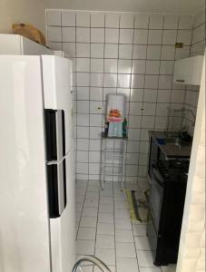 a small kitchen with a refrigerator and a sink at Ap. No centro da cidade in Garanhuns