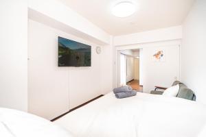 a bedroom with white walls and a large bed at 新宿歌舞伎町東新宿站3分钟，徒步伊势丹4分钟免费Wi-Fi！ in Tokyo