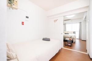 a white bedroom with a bed and a window at 新宿歌舞伎町東新宿站3分钟，徒步伊势丹4分钟免费Wi-Fi！ in Tokyo