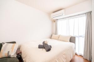 a bedroom with two beds and a window at 新宿歌舞伎町東新宿站3分钟，徒步伊势丹4分钟免费Wi-Fi！ in Tokyo