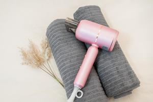 a pink inhaler sitting on top of a gray towel at 新宿歌舞伎町東新宿站3分钟，徒步伊势丹4分钟免费Wi-Fi！ in Tokyo