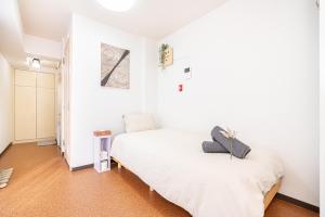 a bedroom with white walls and a white bed at 新宿歌舞伎町東新宿站3分钟，徒步伊势丹4分钟免费Wi-Fi！ in Tokyo