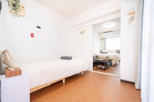 a white bedroom with a bed and a table at 新宿歌舞伎町東新宿站3分钟，徒步伊势丹4分钟免费Wi-Fi！ in Tokyo