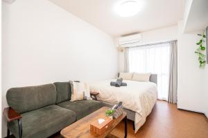 a living room with a couch and a bed at 新宿歌舞伎町東新宿站3分钟，徒步伊势丹4分钟免费Wi-Fi！ in Tokyo